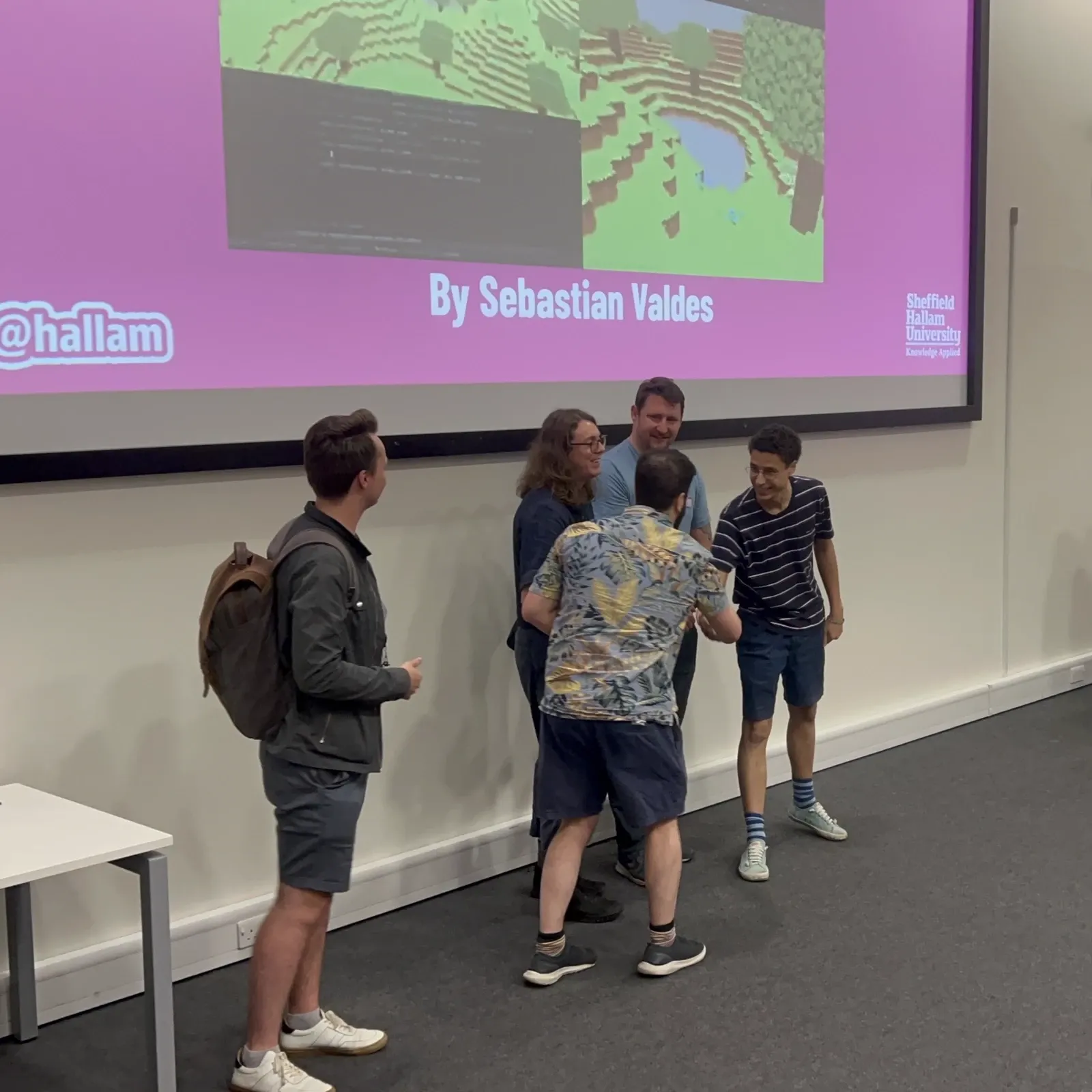 Receiving Best Individual Project at Game Over 25, shaking hands at Sheffield Hallam University